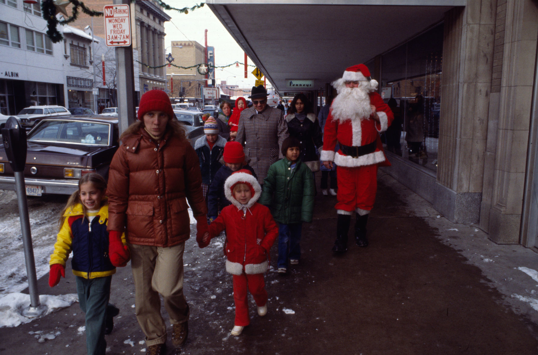 Santa walks with children downtown, 1977